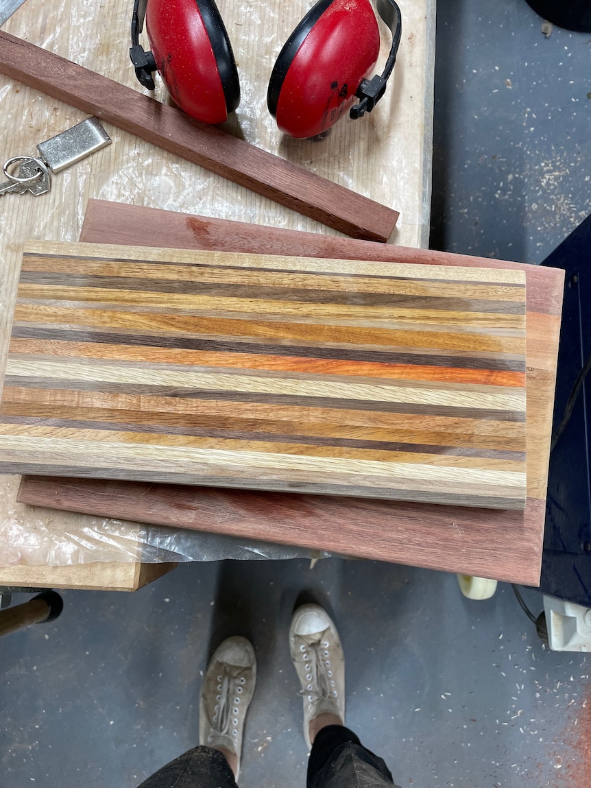 A wooden chopping board on a workbench. 