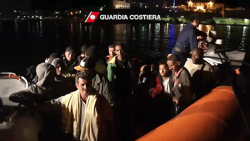 Survivors from an asylum boat sinking are helped by the Italian coast guard