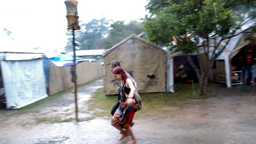 Festival-goers run to avoid a downpour