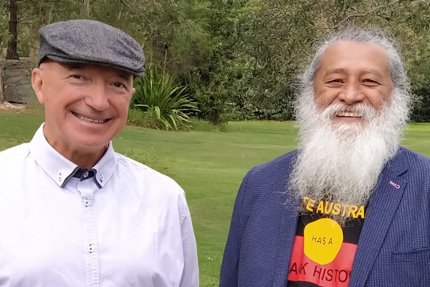 Two men smile in a park