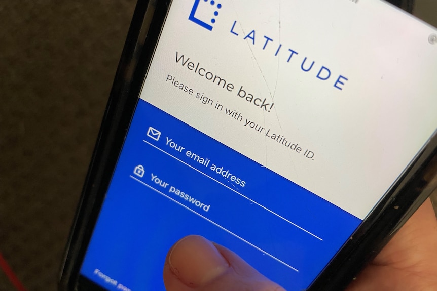 A person holds a smartphone with the Latitude Financial app open. 
