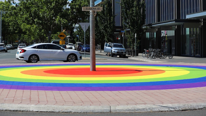 A painted rainbow roundabout.