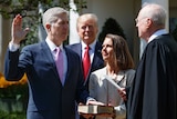 Judge Neil Gorsuch raises his right arm as a re-enactment of the judicial oath is carried out.