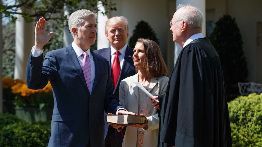 Judge Neil Gorsuch raises his right arm as a re-enactment of the judicial oath is carried out.