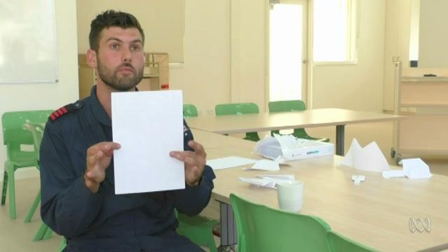 Man holds up piece of paper