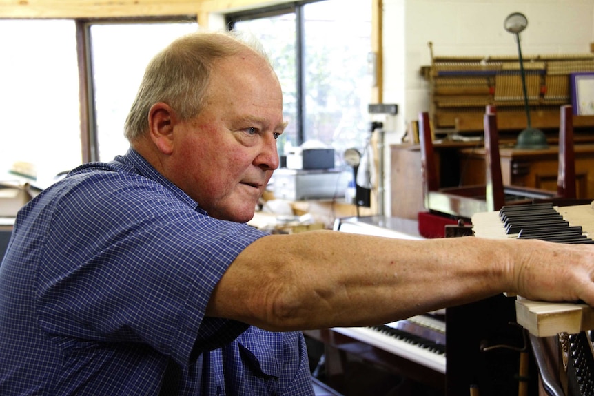 Robert Tucker working on a piano