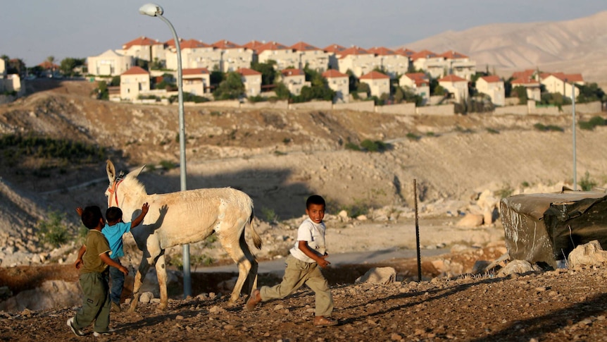 Palestinian children play near a Jewish settlement