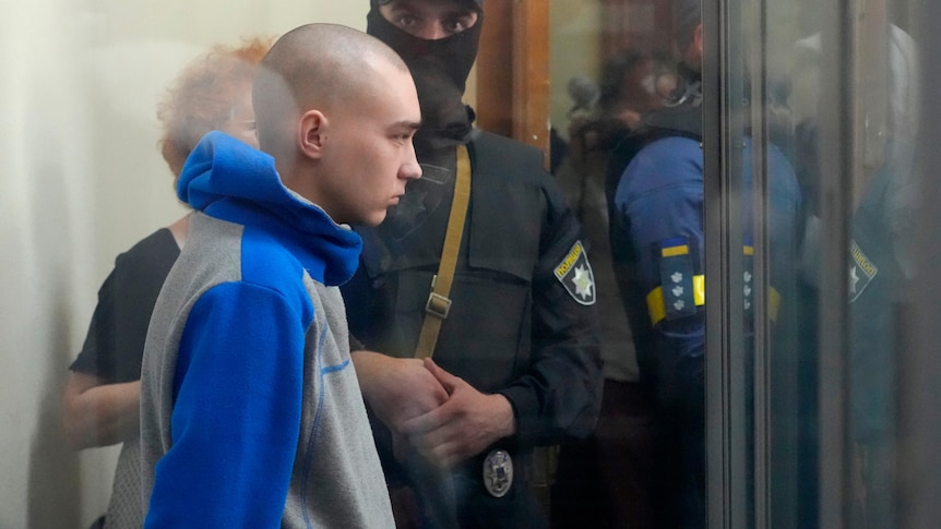 Russian soldier is seen behind a glass during a court hearing