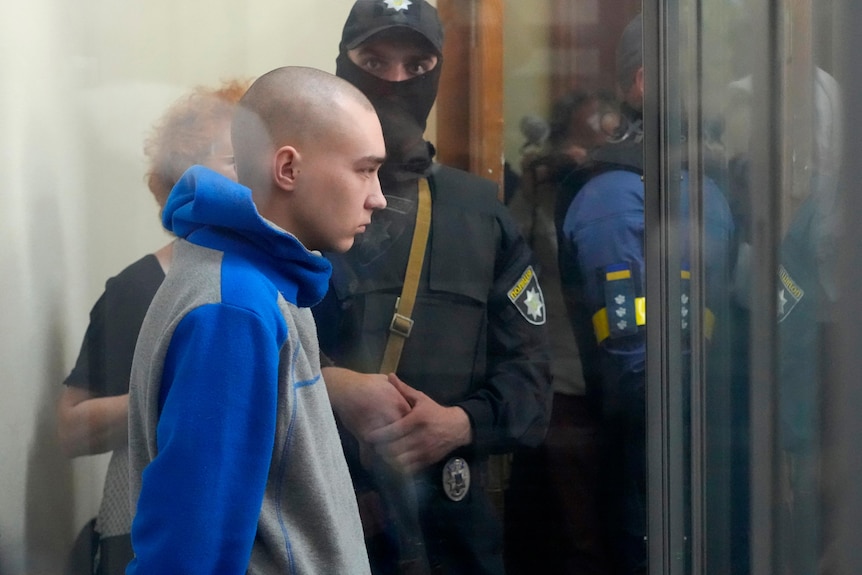 Russian soldier is seen behind a glass during a court hearing