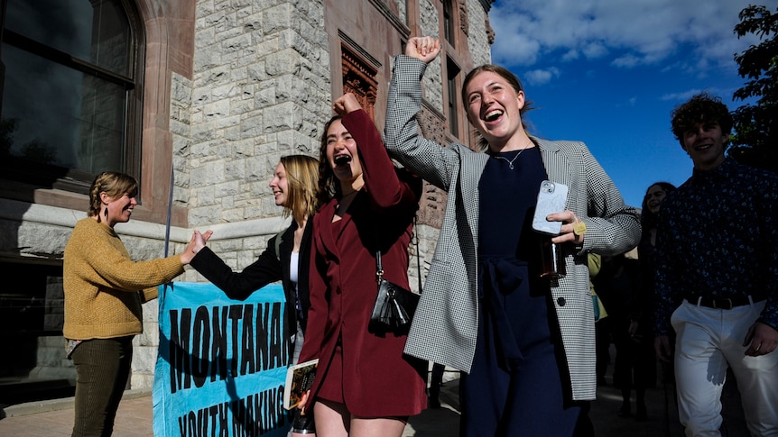 Young women celebrating outside a courthouse.