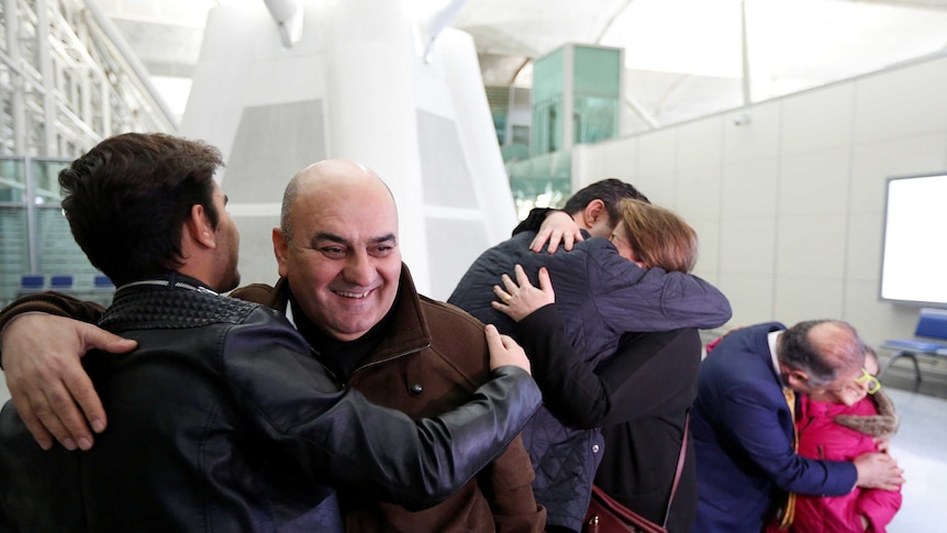 A family embrace before boarding a flight from Iraq to the US