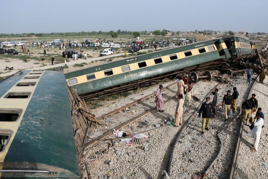 Police officers gather at the site where a train derailed