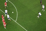An overhead shot of Marcus Rashford striking a free kick as the defensive wall jumps