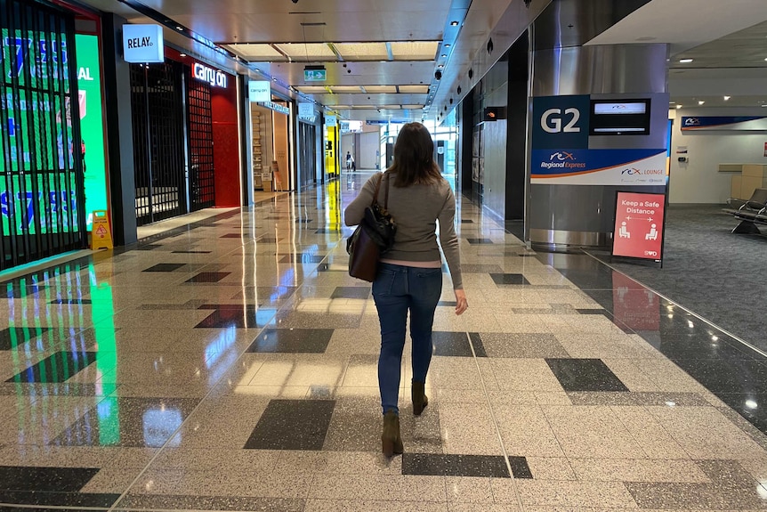 Rachel Pupazzoni walks through a near empty Sydney Airport, where almost all stores are shut.