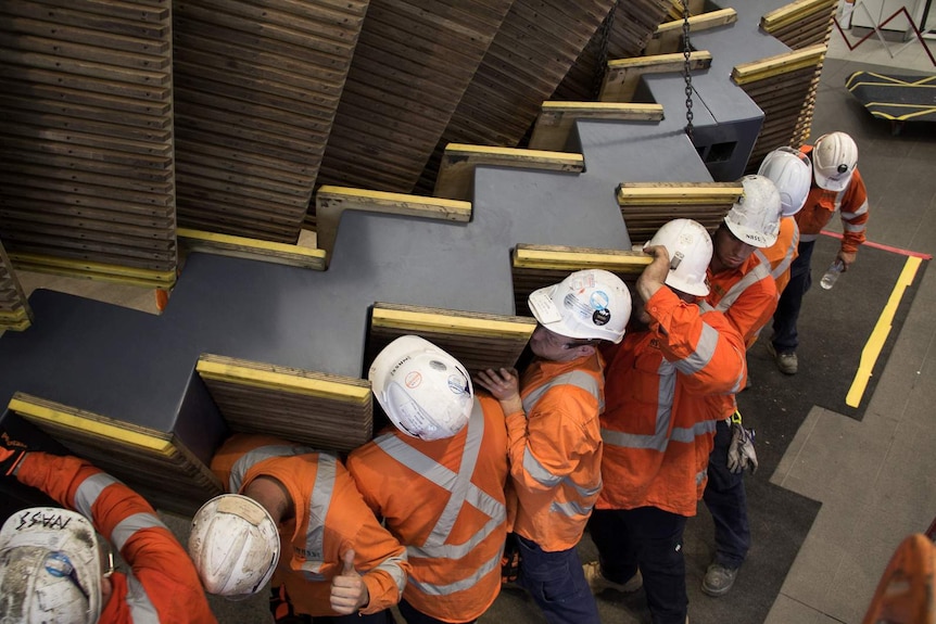 A work crew installing the Interloop sculpture at Wynyard Railway Station.