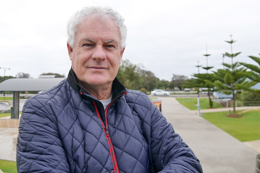 A man standing in front of a skate park with folded arms looking at the camera