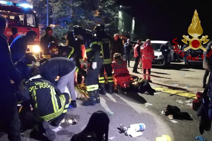 Emergency personnel treat victims late at night after a stampede at an Italian nightclub.