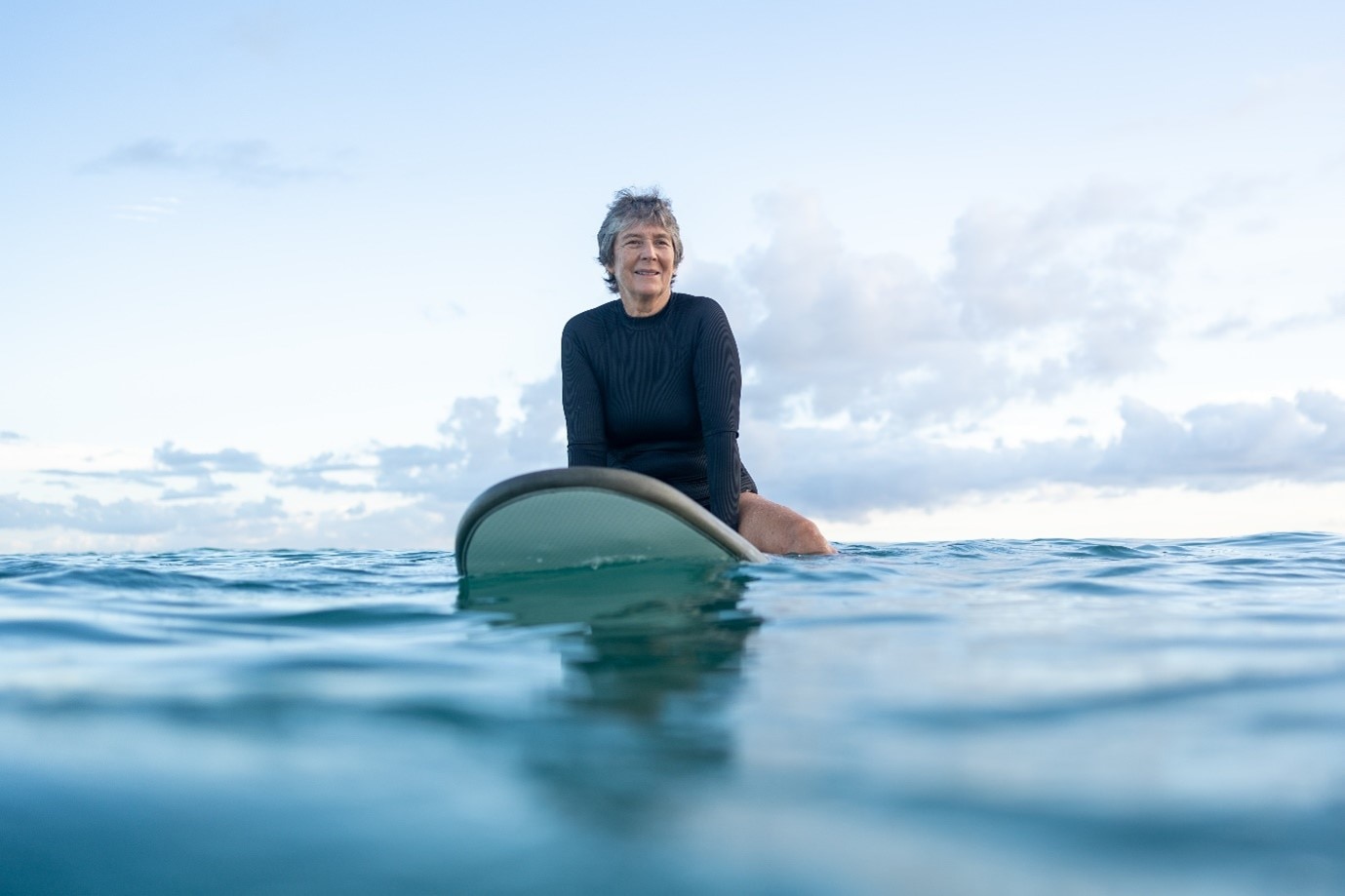women sitting on surfboard in water