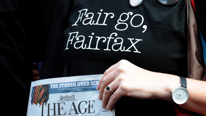 Staff on strike wears shirt saying "Fair go, Fairfax" while holding a copy of The Age newspaper.