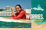 A woman on a surfboard displays the hang ten sign in the new Tourism Australia ad campaign