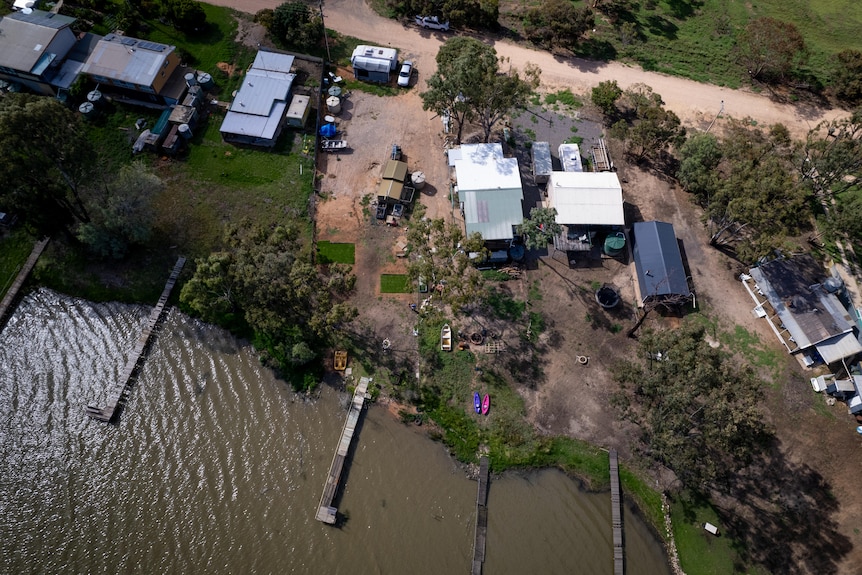 A drone picture of a few properties with flood damage and damaged lawns