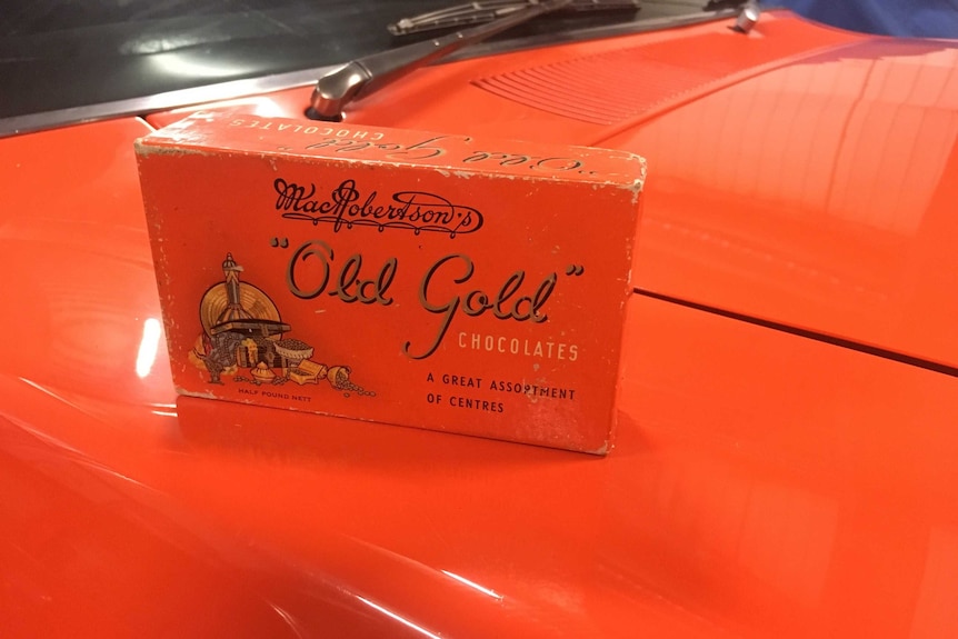 A McRobertson’s Old Gold Chocolate box sits on top of a rare Ford Falcon painted the same colour.