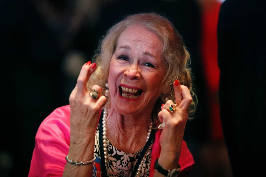 A Republican Senate candidate Rick Scott supporter crosses her fingers at an election watch party