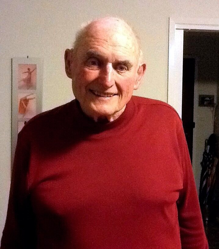 an elderly man smiling and looking at the camera