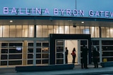 Ballina Byron Gateway airport entrance on dusk. Lights inside the airport terminal are on and the name of the airport is lit up 