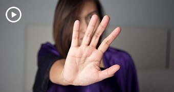 Woman with hand outstretched, obscuring her face.