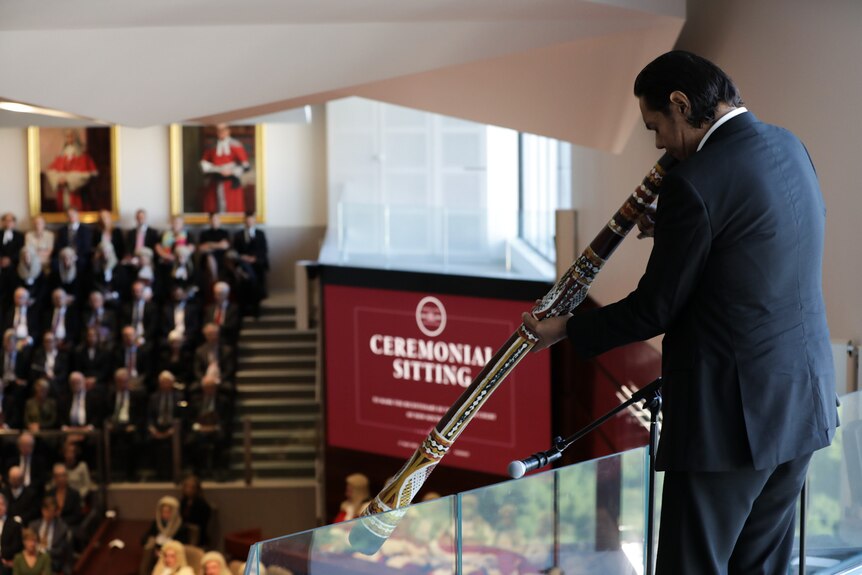a man plays a digeridoo at a ceremony for the new south wales supreme court to mark its 200th birthday