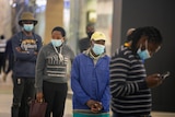 Queue of people wearing blue disposable masks