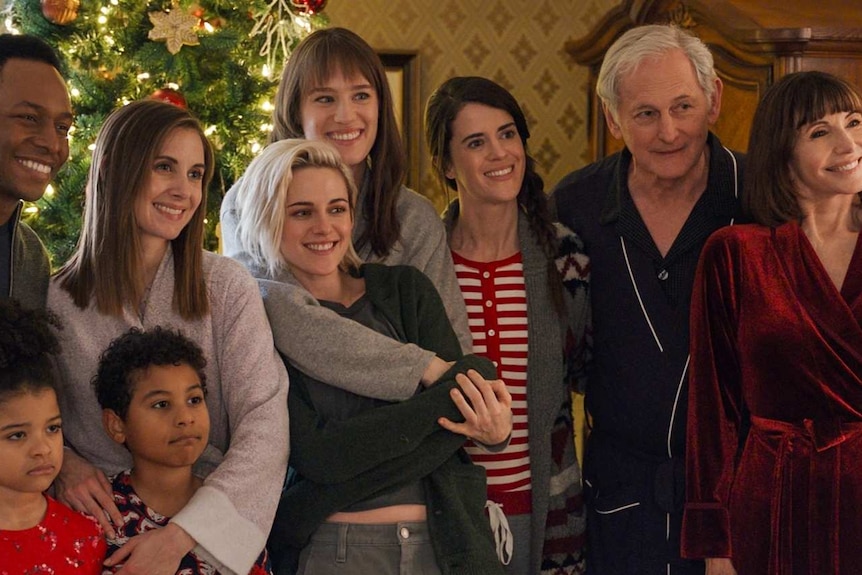 A family standing in front of a Christmas tree in the movie Happiest Season
