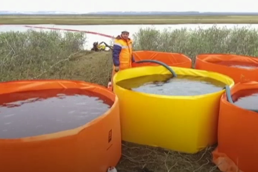 Fuel removed from the river is stored in large round temporary reservoirs on the river bank.