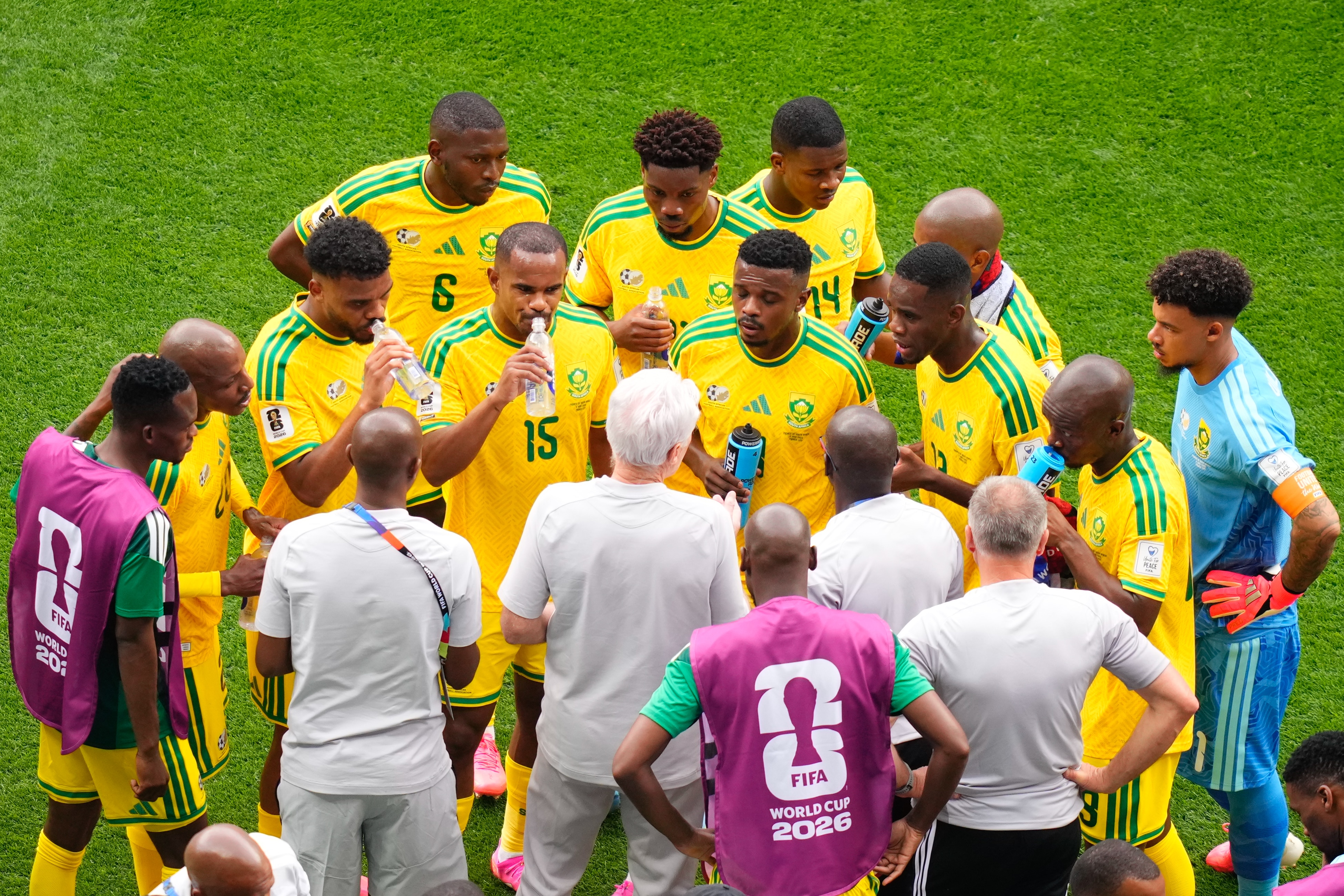 Jogadores e treinadores sul-africanos convergem durante uma pausa para hidratação no meio da partida