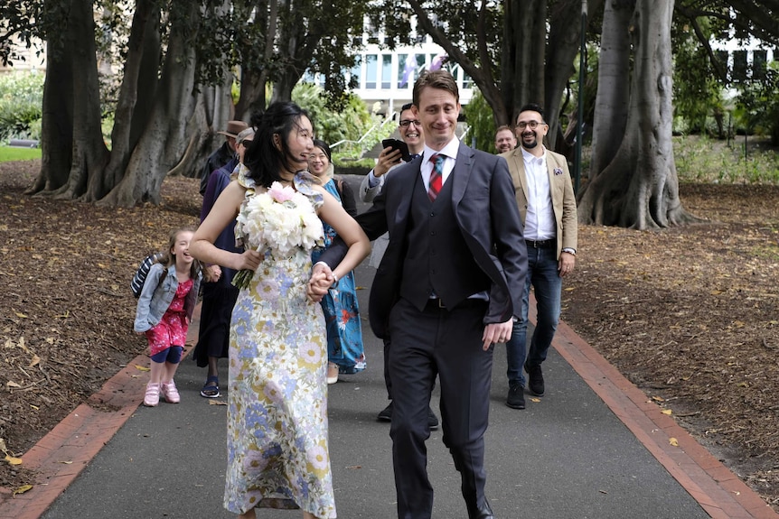 A Chinese woman and an Australian man walking in the Botanical Gardens and smiling.