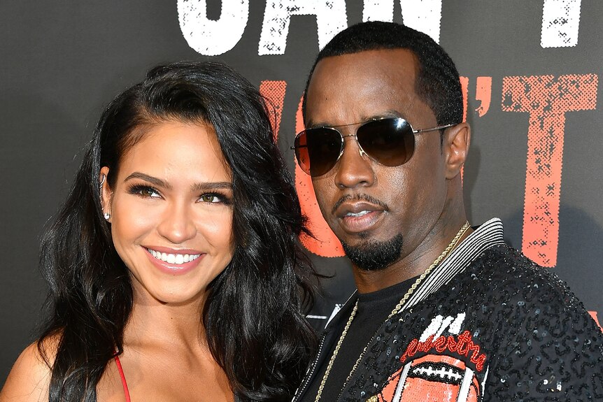 Singer Cassie and Sean Combs pose on the red carpet, Diddy is wearing sunglasses.