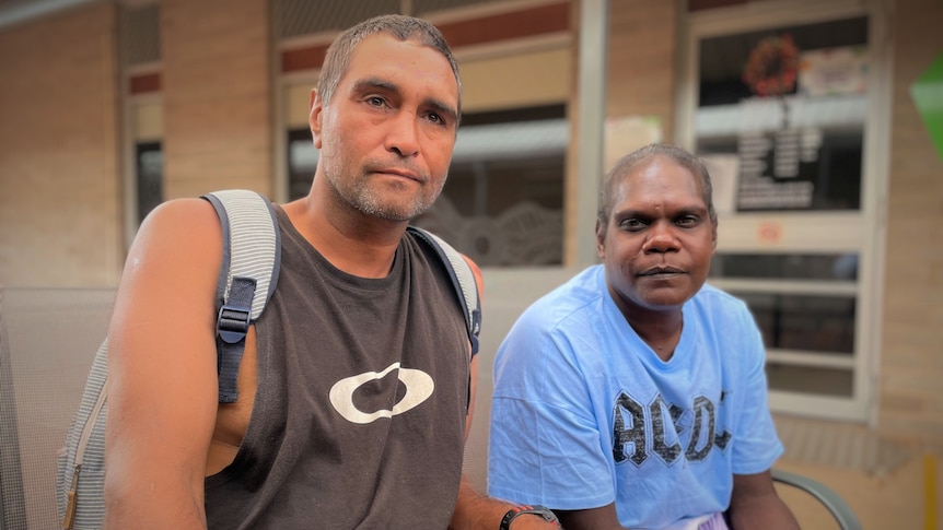 An Indigenous man and a woman sitting outside.