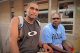 An Indigenous man and a woman sitting outside.