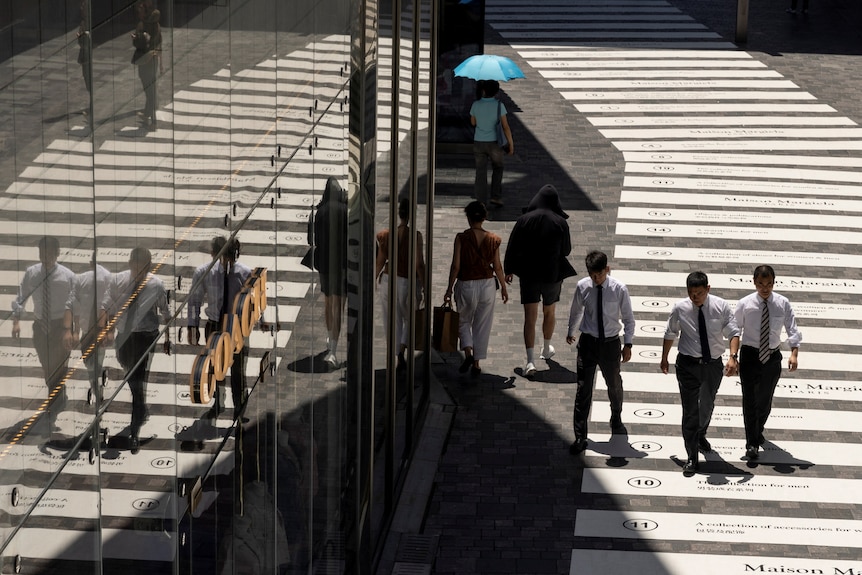 Three young people are walking out from a building 