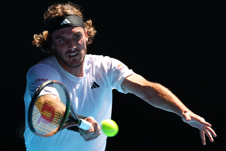A Greek male tennis player hits a forehand during an Australian Open match.