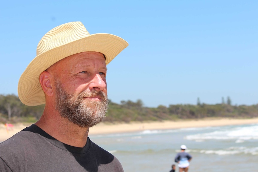 A man wearing a hat at the beach.