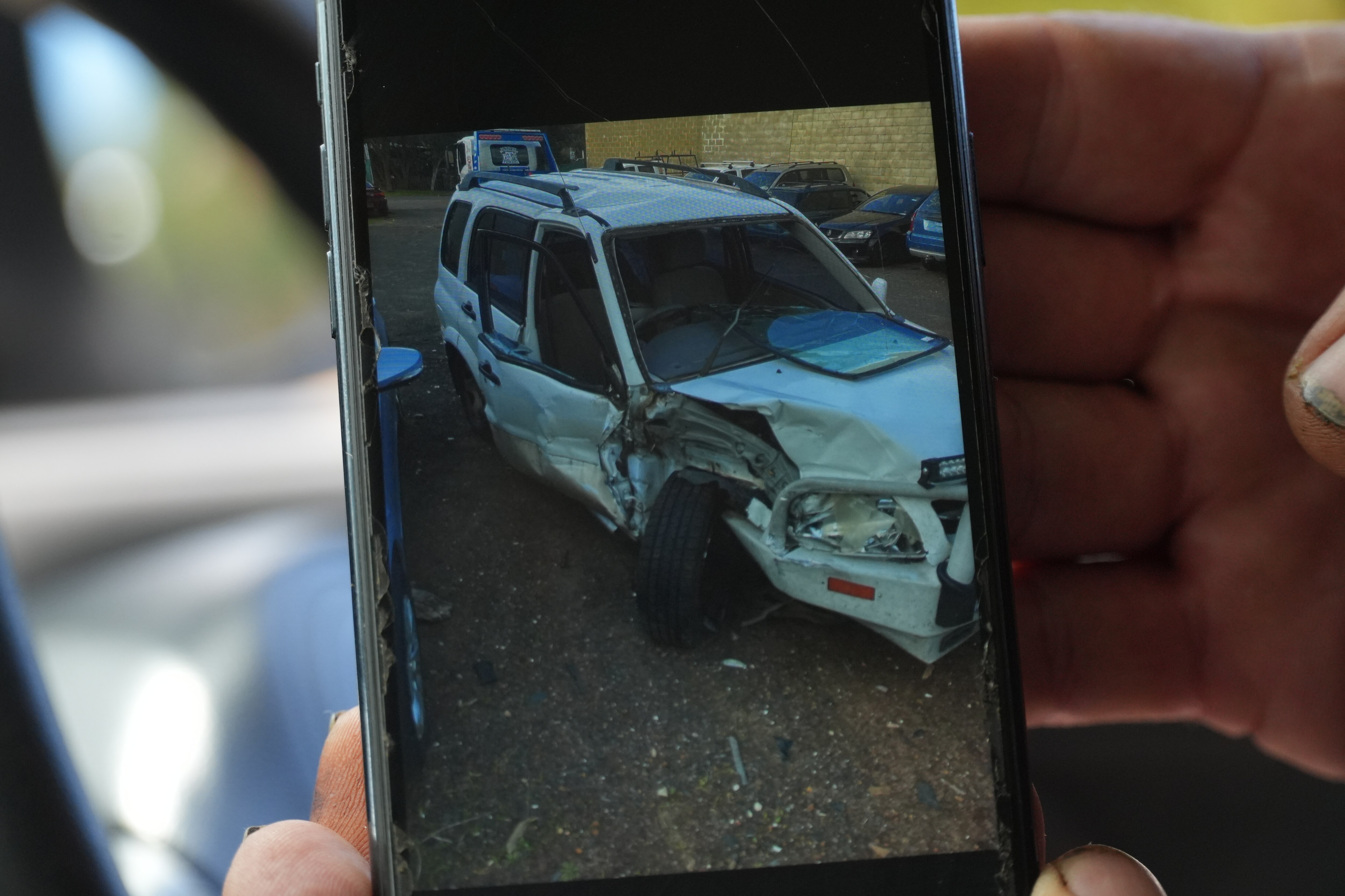 A phone screen showing a wrecked car.