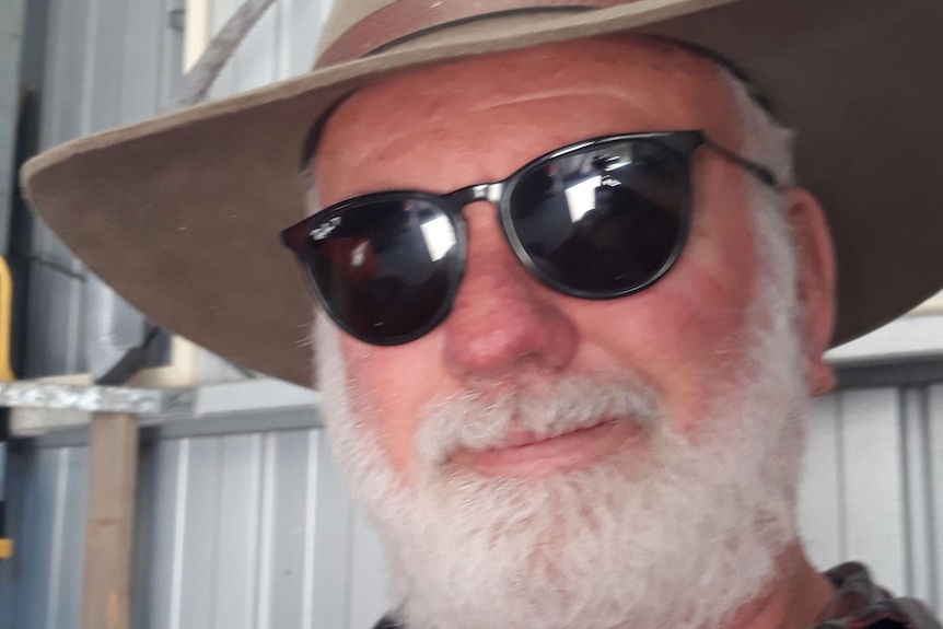 A man with white beard wearing a hat and sunglasses