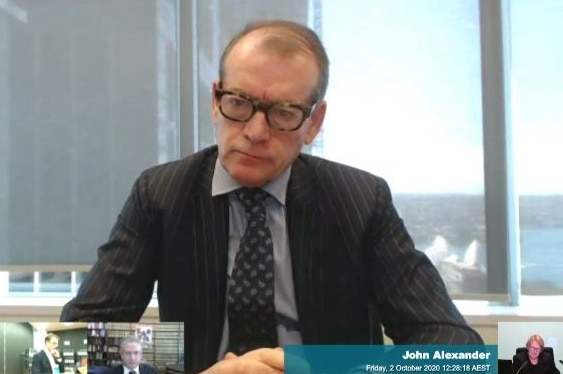 A man in a suit and glasses in an office room.