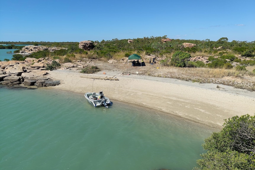 An aerial view of a large sunny bay with a boat in the water