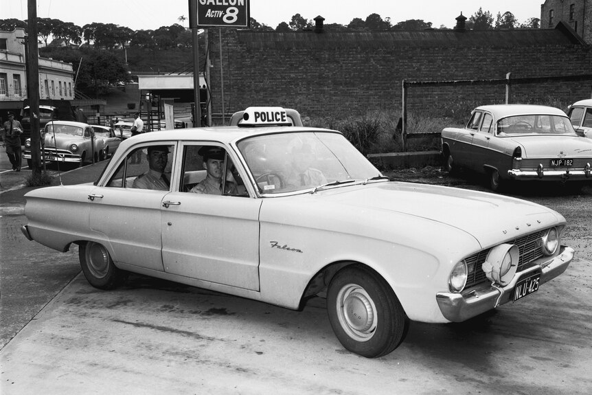 A black and white photo of vintage QLD police car