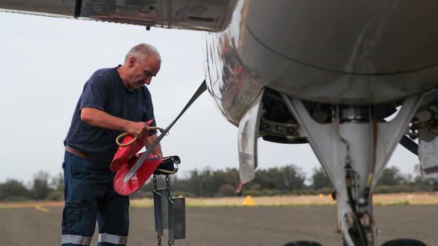 A RFDS pilot unties the plane's propellers in Ivanhoe, NSW, Dec 2019