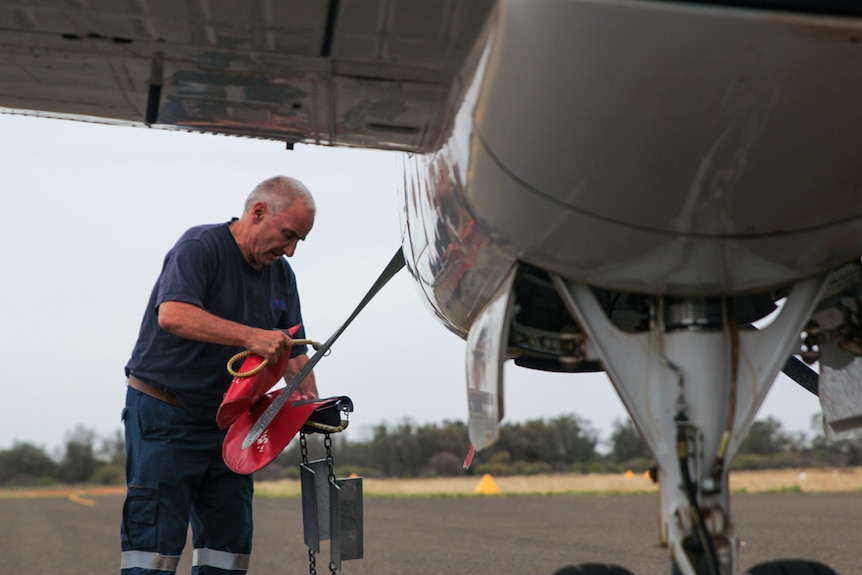 A RFDS pilot unties the plane's propellers in Ivanhoe.