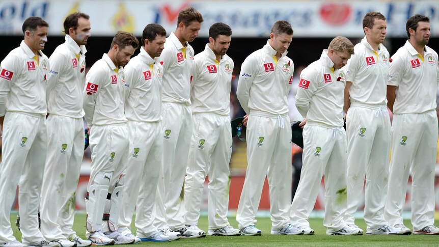 The Australian team pays its respects during the Gabba's Remembrance Day ceremony.